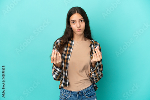 Young French woman isolated on blue background making money gesture but is ruined © luismolinero