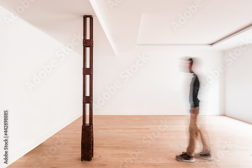 Man standing in gallery with creative art object photo