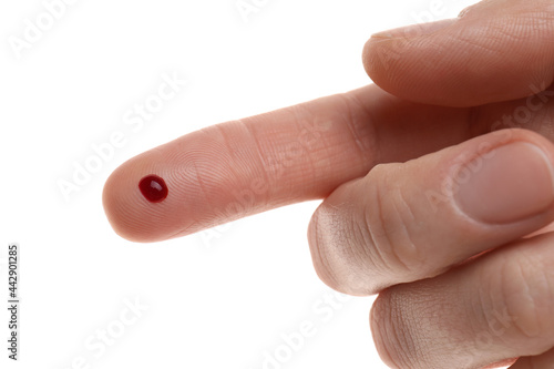 Woman with pricked finger and blood drop on white background, closeup