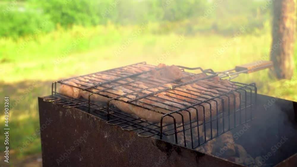 Cooking sausages on a cast iron grill in the open air close-up. Pitknik. Cooking sausages on a cast iron grill in the open air close-up. Pitknik.