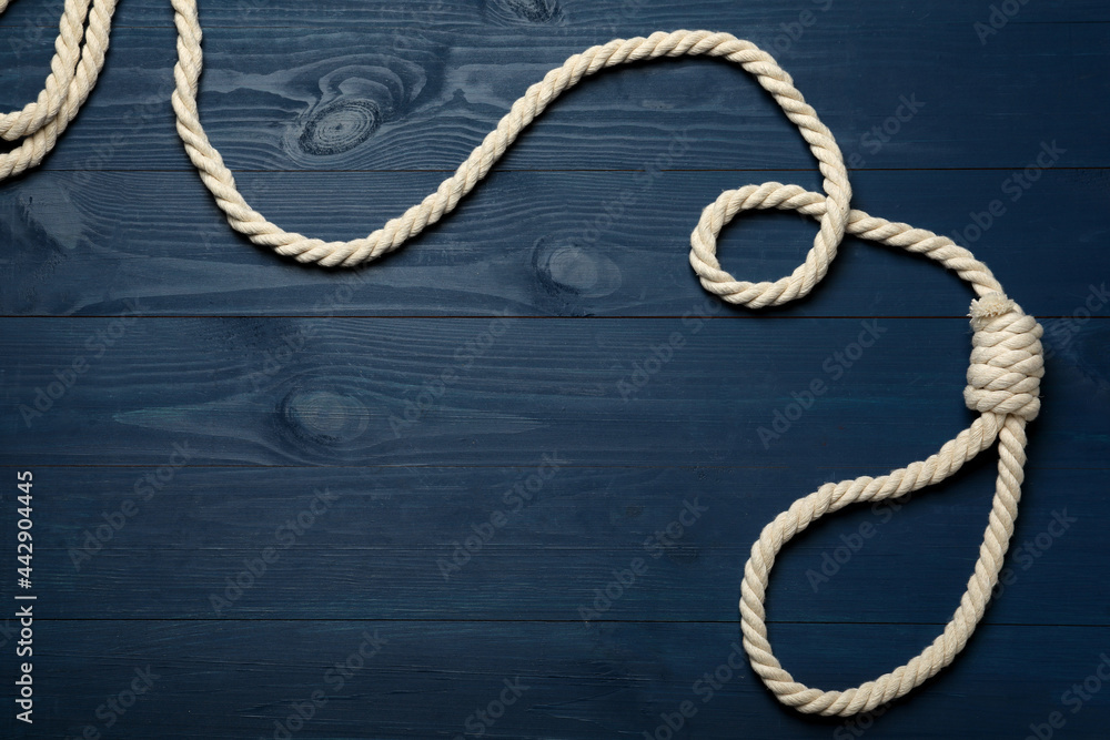 Rope noose with knot on blue wooden table, top view. Space for text Rope noose with knot on blue wooden table, top view. Space for text