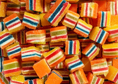 Colorful square jelly candies background. Yellow, pink, red, orange, white, green square shaped marmalade backdrop.
