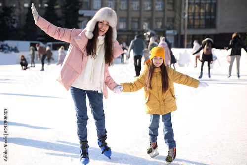 Mother and daughter spending time together at outdoor ice skating rink