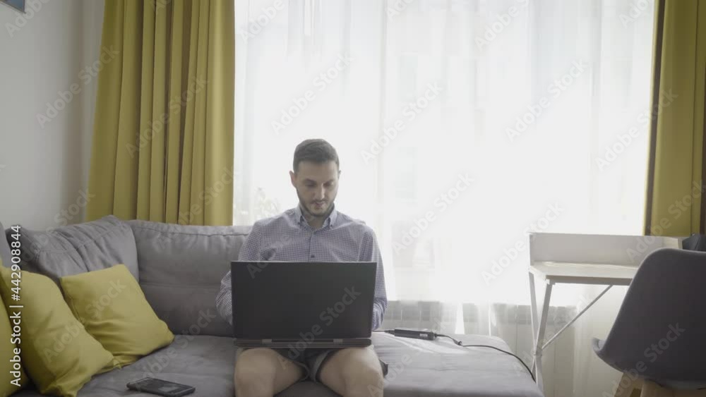 Millennial man working on laptop at home trading cryptocurrency Millennial man working on laptop at home trading cryptocurrency