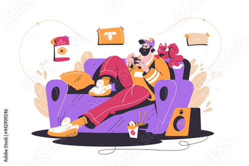 Bearded man playing in video game at sofa with cat.