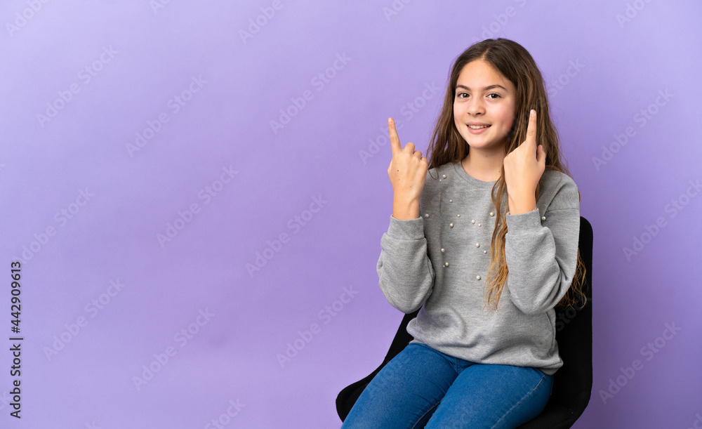 Little caucasian girl sitting on a chair isolated on purple background pointing up a great idea Little caucasian girl sitting on a chair isolated on purple background pointing up a great idea