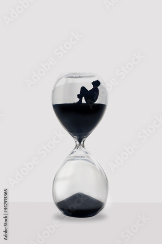 Illustration: Man sitting inside an hourglass wait for time to pass. Ideal concept for depression, loneliness, mental health problems, sadness and anxiety patients.