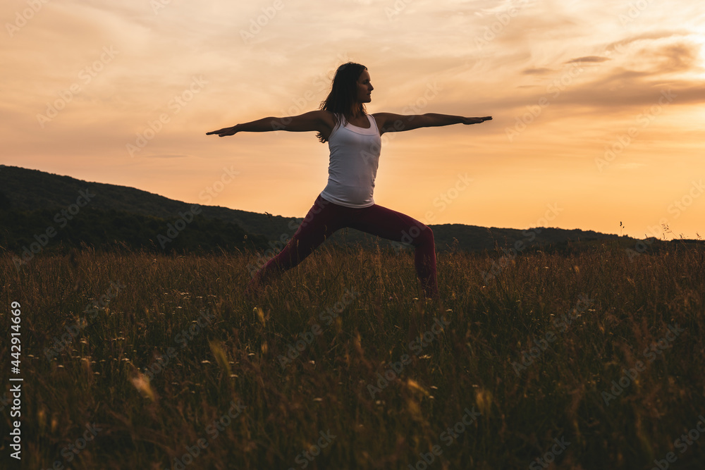Silhouette of a woman practicing yoga/Virabhadrasana,Warrior Pose. Silhouette of a woman practicing yoga/Virabhadrasana,Warrior Pose.