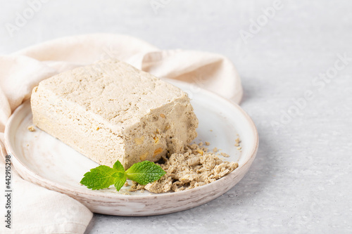 sunflower halva and peanuts on grey plate with mint, napkin