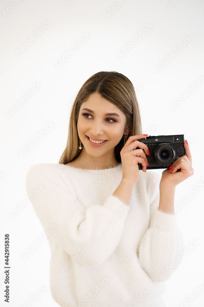 Beautiful Hipster woman taking photos with black retro film camera on white background. Close up. Indoor. Warm color. Blogger Beautiful Hipster woman taking photos with black retro film camera on white background. Close up. Indoor. Warm color. Blogger