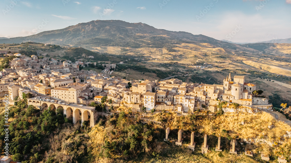Aerial view of medieval stone village,the highest village in Madonie mountain range,Sicily,Italy.Church of Santa Maria di Loreto at sunset.Picturesque stone houses,narrow cobbled streets,views of town