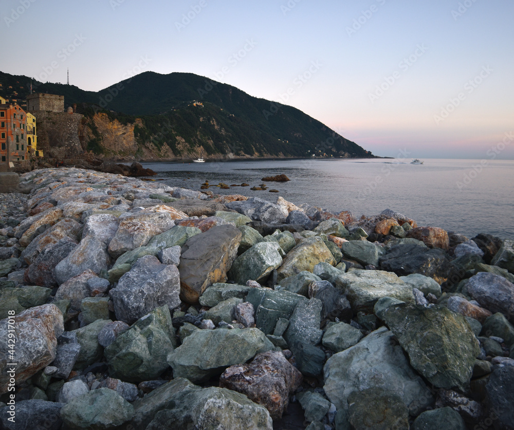 wonderful sunset over the sea in Camogli, colorful rocks frame this glimpse of paradise