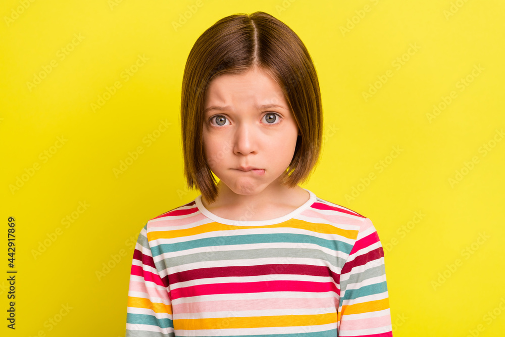 Photo of young unhappy small upset girl bad mood cry face bite lip isolated on shine yellow color background Photo of young unhappy small upset girl bad mood cry face bite lip isolated on shine yellow color background