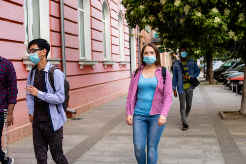 People in medical masks walking on street
