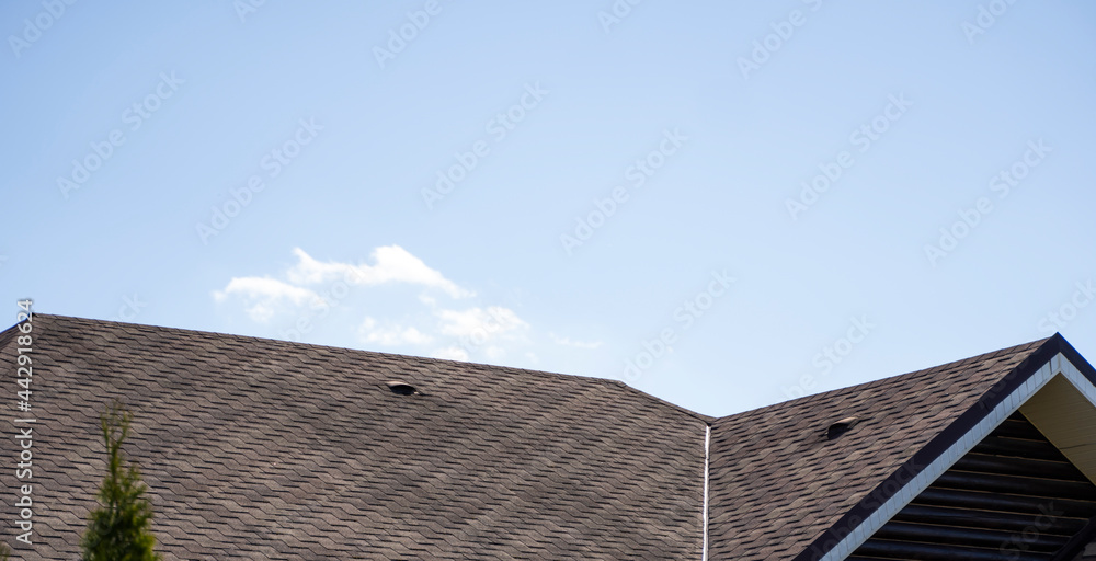 Brown corrugated metal profile roof installed on a modern house. The roof of corrugated sheet. Roofing of metal profile wavy shape. Modern roof made of metal. Metal roofing. Brown corrugated metal profile roof installed on a modern house. The roof of corrugated sheet. Roofing of metal profile wavy shape. Modern roof made of metal. Metal roofing.