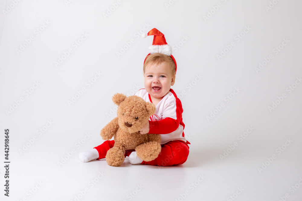 baby boy in santa hat with gifts on white background