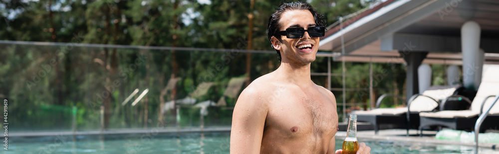 happy shirtless man in sunglasses relaxing in pool with bottle of beer, banner happy shirtless man in sunglasses relaxing in pool with bottle of beer, banner