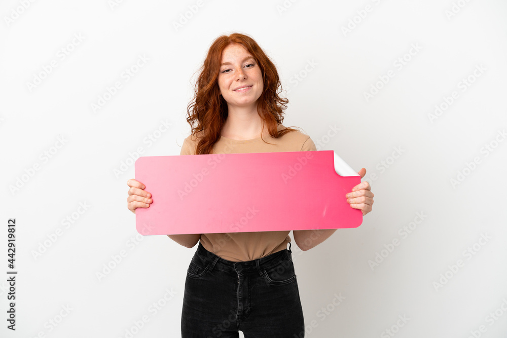 Teenager redhead girl isolated on white background holding an empty placard Teenager redhead girl isolated on white background holding an empty placard