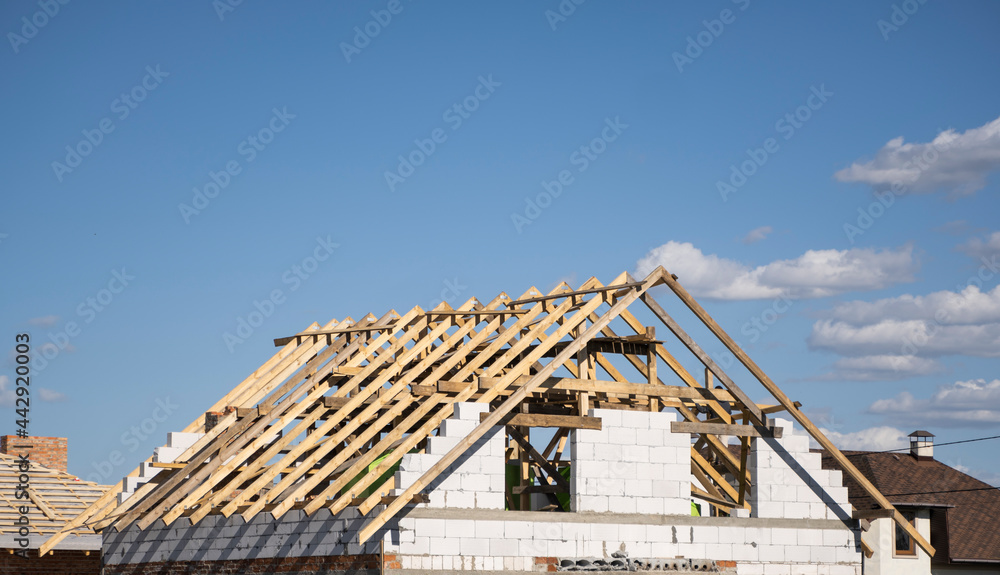 Wooden roof construction against blue sky. House building.