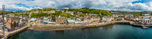 Fototapeta Naklejka Na Ścianę i Meble -  A panorama aerial view across the seafront in the town of Oban, Scotland on a summers day