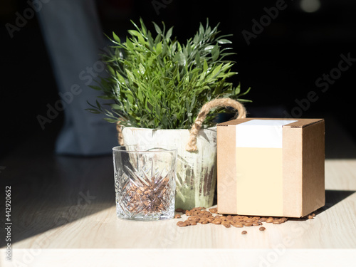 mockup box of coffee. A box of coffee in the sun. A glass cup of coffee. Coffee Packaging