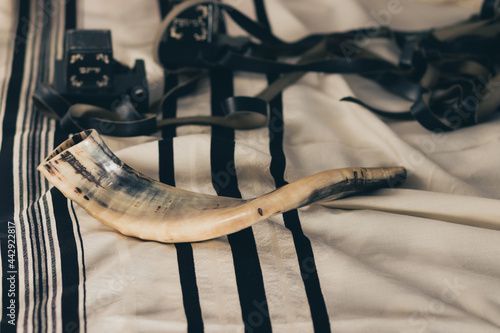 shofar on a tallit with black stripes, next to tefillin (jewish religious objects for the holidays) photo