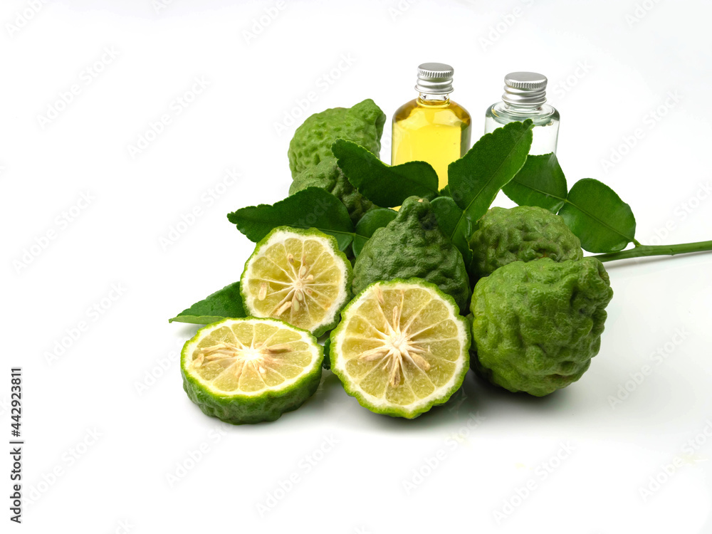 kaffir lime fruit, leaves and bergamot essential oil in a bottle isolated on a white background. kaffir lime fruit, leaves and bergamot essential oil in a bottle isolated on a white background.