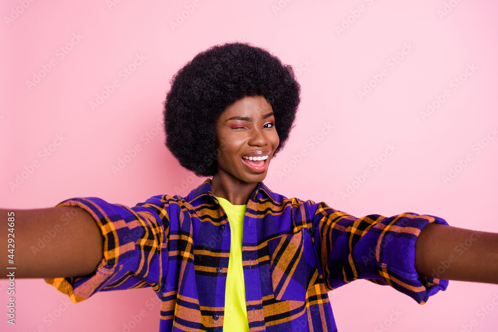 Self-portrait of attractive coquettish cheerful girl wearing checked shirt winking you isolated over pink pastel color background Self-portrait of attractive coquettish cheerful girl wearing checked shirt winking you isolated over pink pastel color background