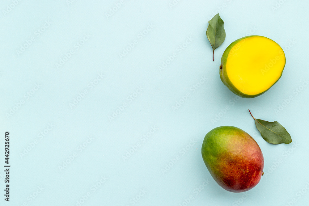 Layout of mango and leaves. Tropical fruits background Layout of mango and leaves. Tropical fruits background