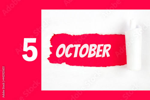 October 5th. Day 5 of month, Calendar date. Red Hole in the white paper with torn sides with calendar date. Autumn month, day of the year concept. photo