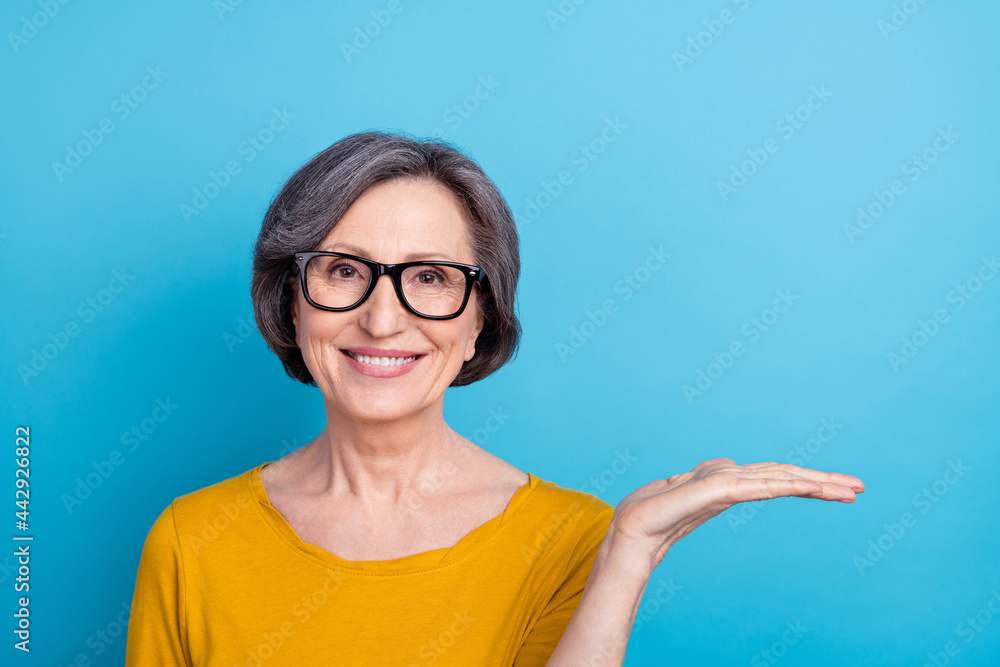 Portrait of attractive cheerful woman holding on palm copy empty space solution isolated over bright blue color background Portrait of attractive cheerful woman holding on palm copy empty space solution isolated over bright blue color background