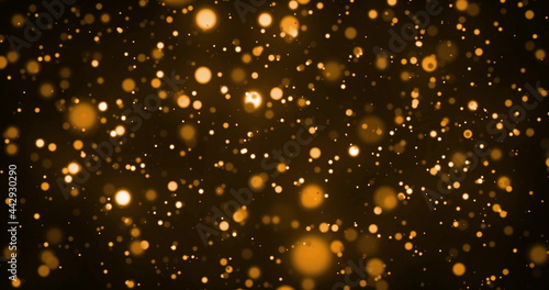 Image of glowing gold spots of light moving in hypnotic motion on brown background