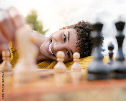 Black woman playing chess in park photo