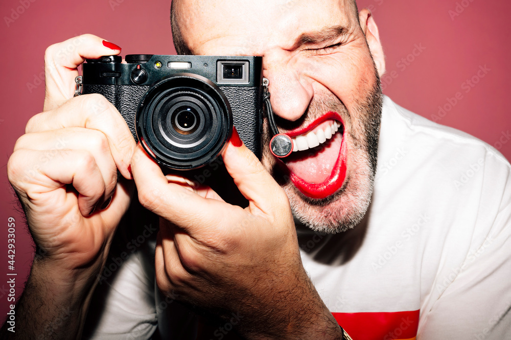 Cheerful guy with makeup taking photo on camera with opened mouth Cheerful guy with makeup taking photo on camera with opened mouth