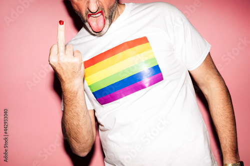 Anonymous homosexual man with makeup and beard showing middle finger photo