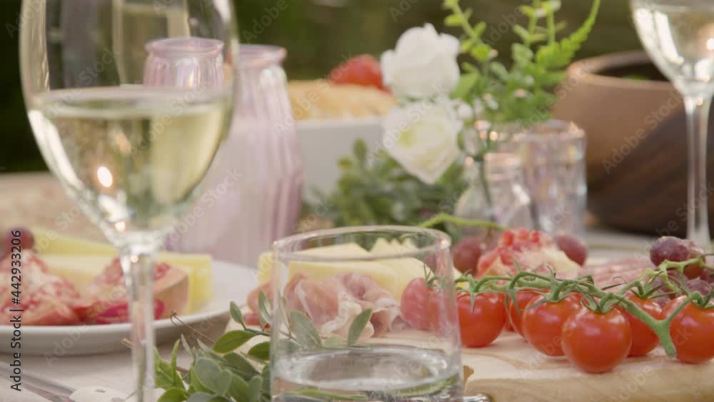 Pull Focus Shot from an Alfresco Dinner Table Spread to Glass of White Wine Pull Focus Shot from an Alfresco Dinner Table Spread to Glass of White Wine