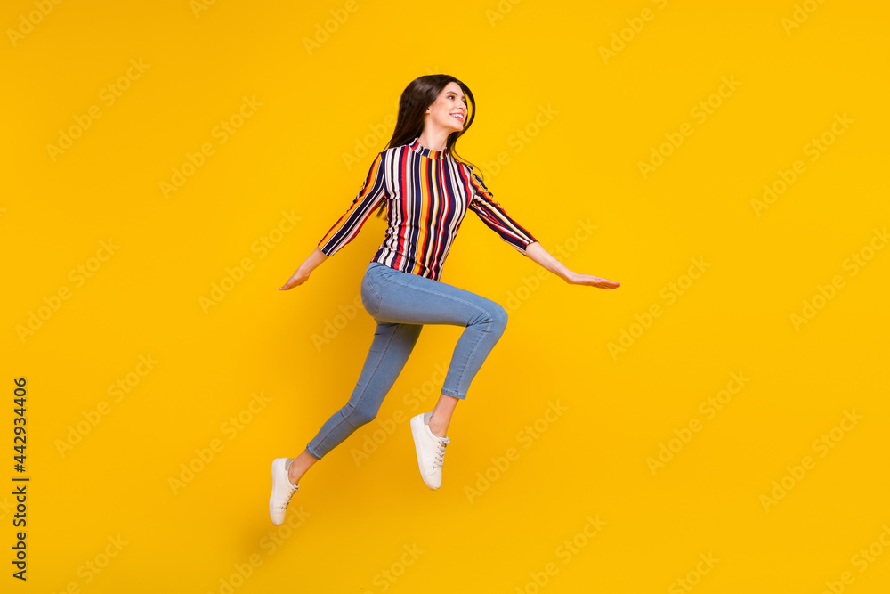 Full size profile side photo of young woman happy positive smile jump up fly go walk run isolated over yellow color background