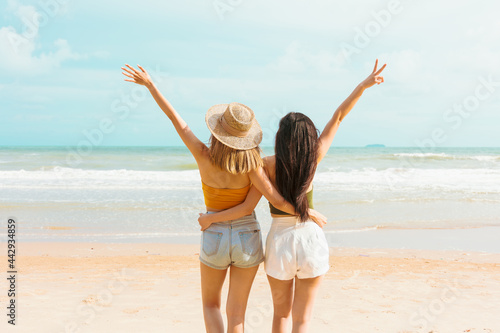 Two Asian women in summer casual clothes play in the sea on vacation in tropical country.