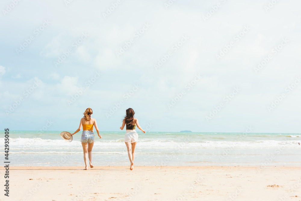 Two Young Asian woman on vacation walking and enjoy the seaside.