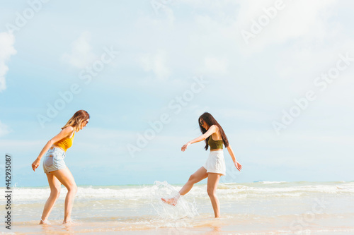 Photography Two Asian women in summer casual clothes play in the sea on the Beach Having Fun