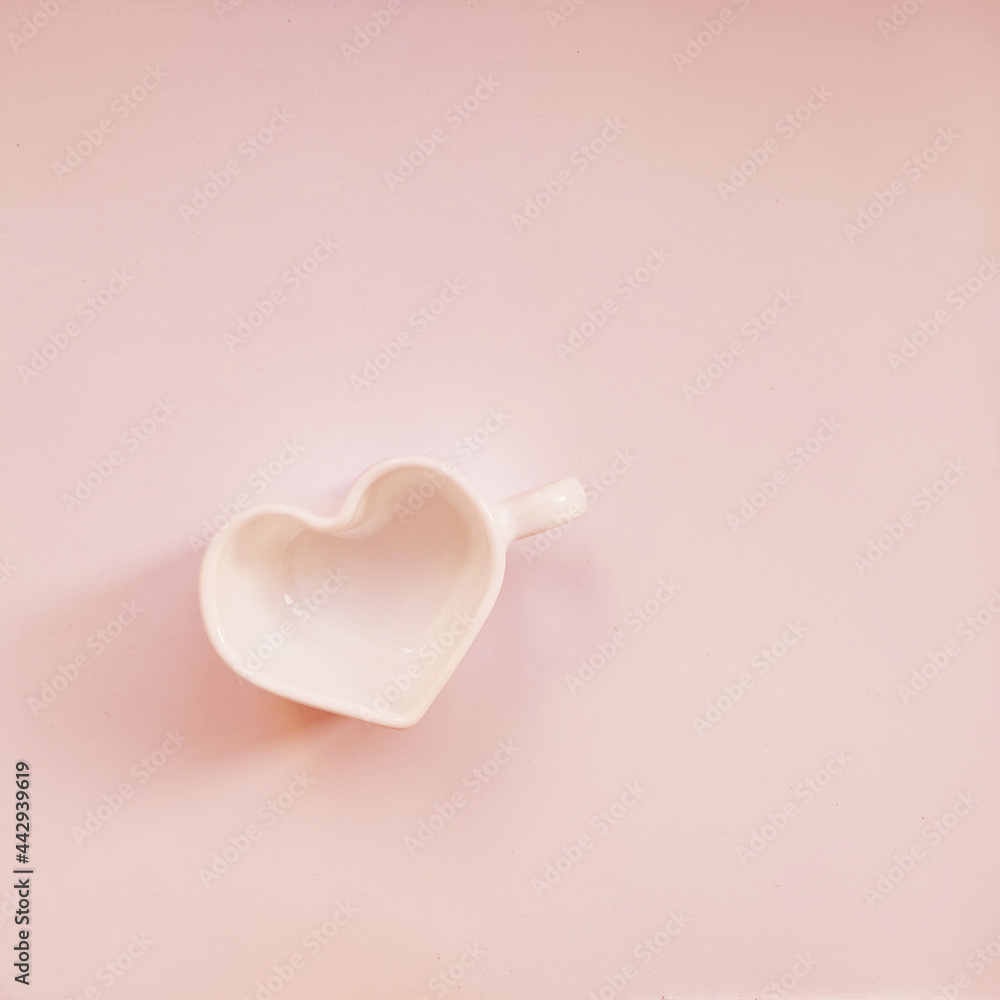 Small mug in form of heart on isolated pink background