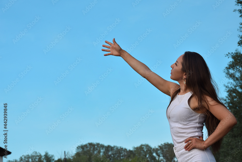 Young Asian woman pointing hand at blue sky Young Asian woman pointing hand at blue sky