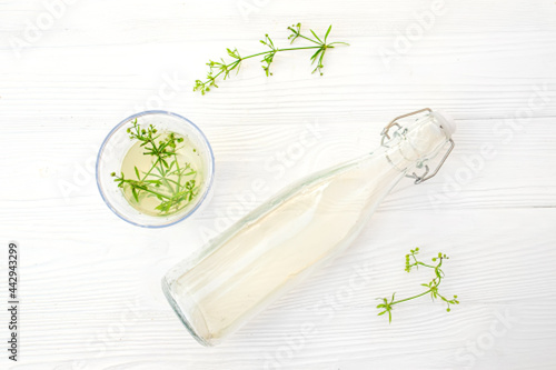 bottle with a tincture. Therapeutic elexir and fresh gallium sprouts on a white background photo