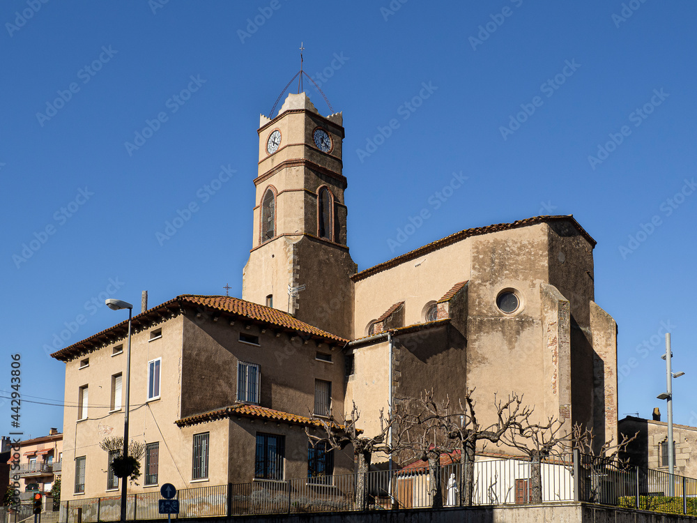 Parroquia de Santa Maria del Prat en LLinars del Valles, en Cataluña, con un cielo azul y su reloj en la torre, octubre 2020