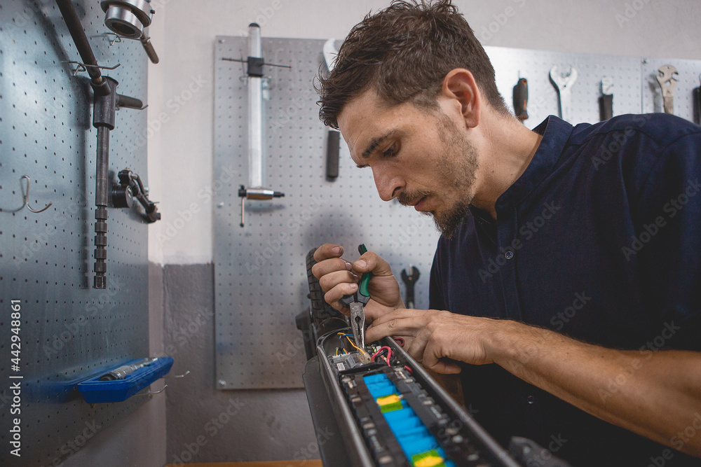 Mechanic checking electric scooter with multimeter Stock Photo Adobe