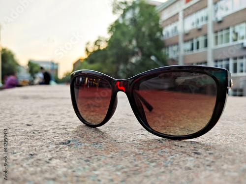 Sunglasses on the pavement in the rays of the setting sun