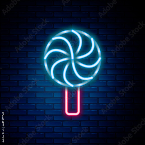 Glowing neon line Lollipop icon isolated on brick wall background. Candy sign. Food, delicious symbol. Colorful outline concept. Vector