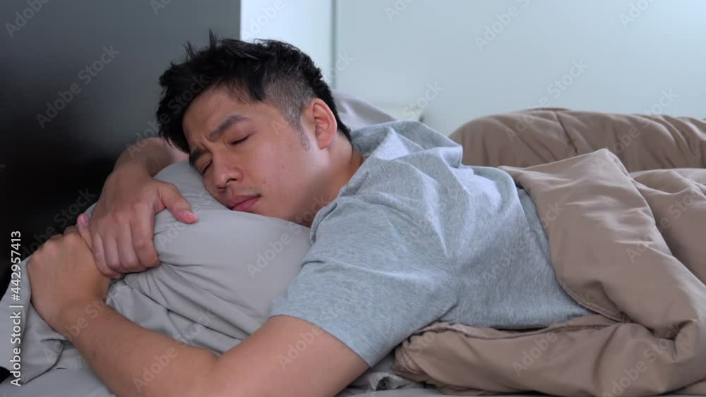 Depressed young Asian man cannot sleep from insomnia. Depressed man suffering from insomnia. Depressed young Asian man cannot sleep from insomnia. Depressed man suffering from insomnia.