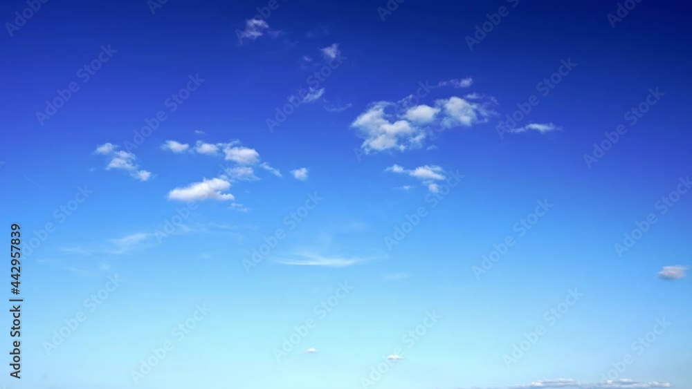 Time-lapse of the white clouds changing shape, and eventually disappearing in the blue sky Time-lapse of the white clouds changing shape, and eventually disappearing in the blue sky