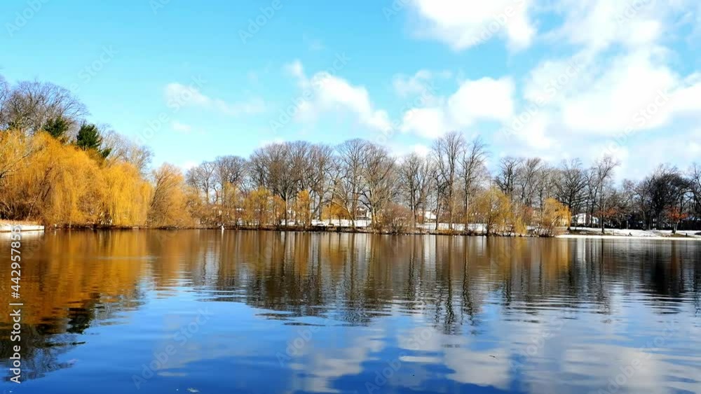 The beautiful lakeside view of autumn, surrounding trees, and their reflections in the water The beautiful lakeside view of autumn, surrounding trees, and their reflections in the water